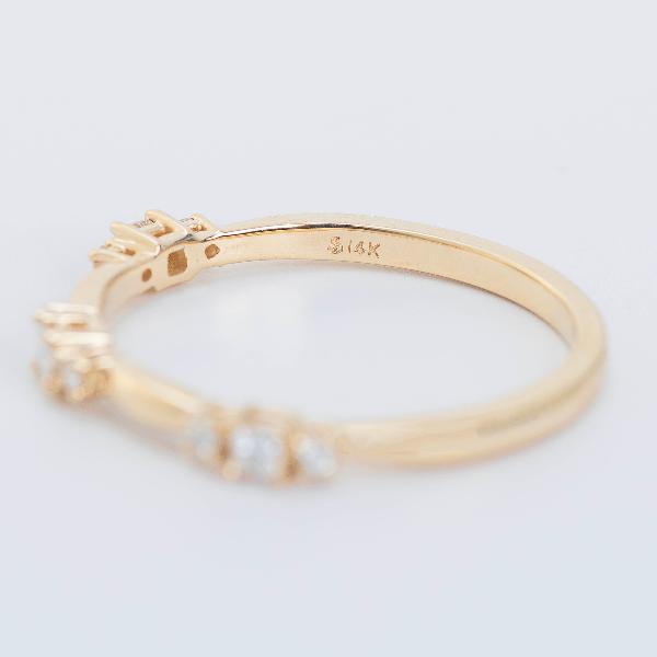 A 14K yellow gold ring part of the Goddess Jewelry collection, features a subtle design with 1/6 CTW natural diamonds. It's displayed against a soft, light gray background.