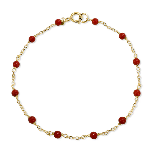 The 14k Red Coral Station Bracelet   from the Goddess Jewelry Collection is a delicate solid gold chain adorned with evenly spaced small red coral stones and a simple gold clasp.