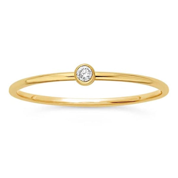 A delicate 14K gold ring by Rio Grande features a solitary lab-grown diamond in a minimal bezel setting, shown on a white background.