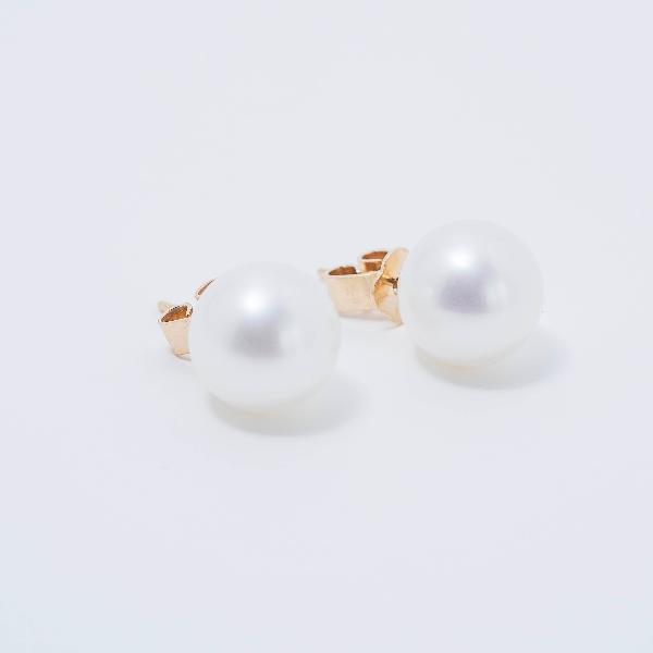 A pair of 14k white 9mm freshwater pearl stud earrings from Jewelmak with glossy, spherical pearls on a plain white background; partially visible gold backings are present behind the pearls.