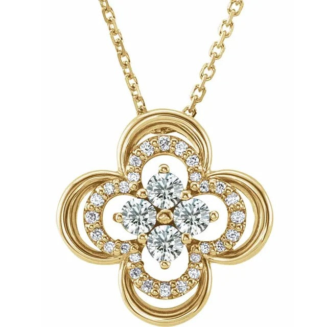 A gold pendant necklace in a four-leaf clover shape with intricate loops embodies the elegance of Goddess Jewelry. The center features four sparkling diamonds, surrounded by a series of smaller diamonds along the edges, all gracefully suspended from a delicate gold chain.