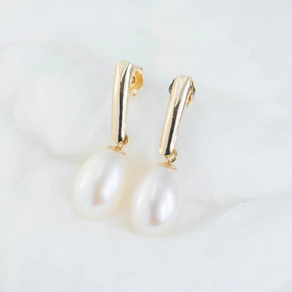 14K Yellow Gold Freshwater Pearl Drop Earrings, gracefully showcased against a soft, fluffy white backdrop.