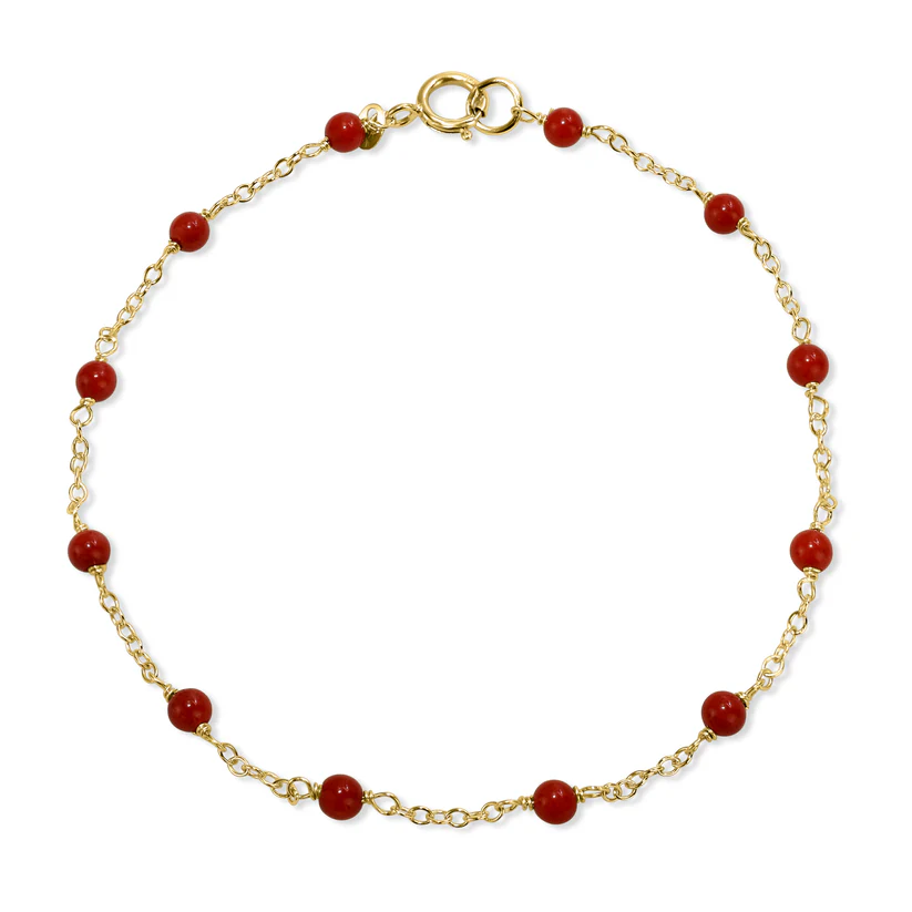 The Jewelmak 14k Red Coral Station Bracelet is a delicate solid gold chain adorned with evenly spaced small red coral stones and a simple gold clasp.