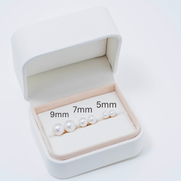 A white jewelry box contains three pairs of exquisite pearl earrings, each featuring freshwater pearls arranged in 9mm, 7mm, and 5mm sizes from largest to smallest. Set in luxurious yellow solid gold to accentuate their graceful size variation.