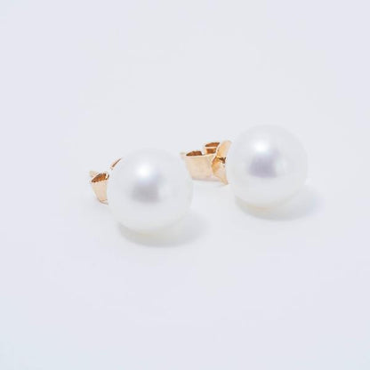 A pair of 14k White 9mm Freshwater Pearl Stud Earrings rests elegantly on a white background.