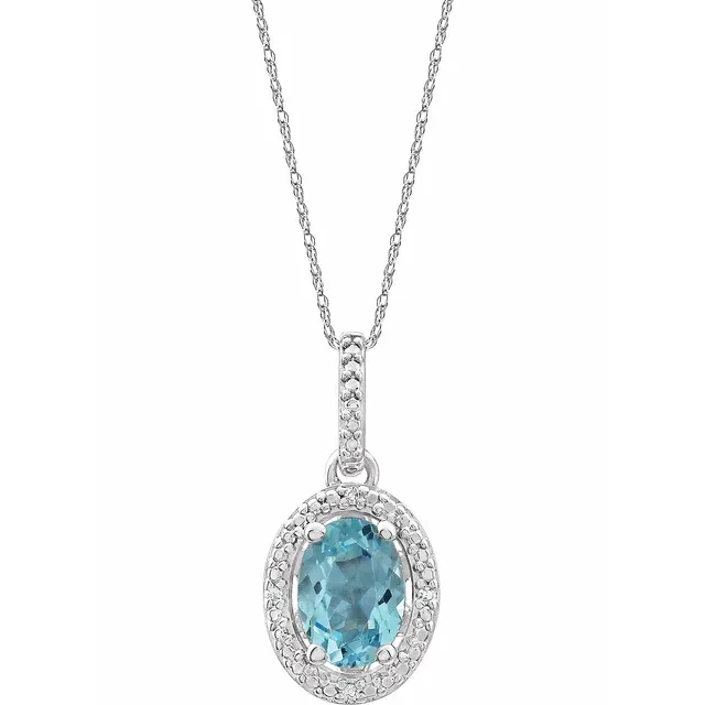 The Stuller Sterling Silver Natural Sky Blue Topaz Oval Necklace features a detailed oval pendant surrounded by a halo of natural diamonds on a thin silver chain, set against a white background.